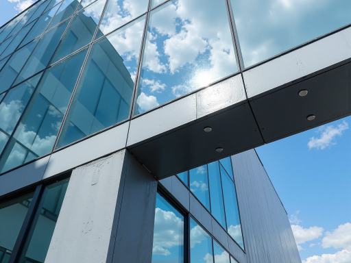 Hospital building undergoing glass facade renovation, construction equipment visible, medical facility exterior